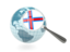 Фарерские острова. Флаг под увеличительным стеклом с голубым глобусом. Скачать иллюстрацию.
